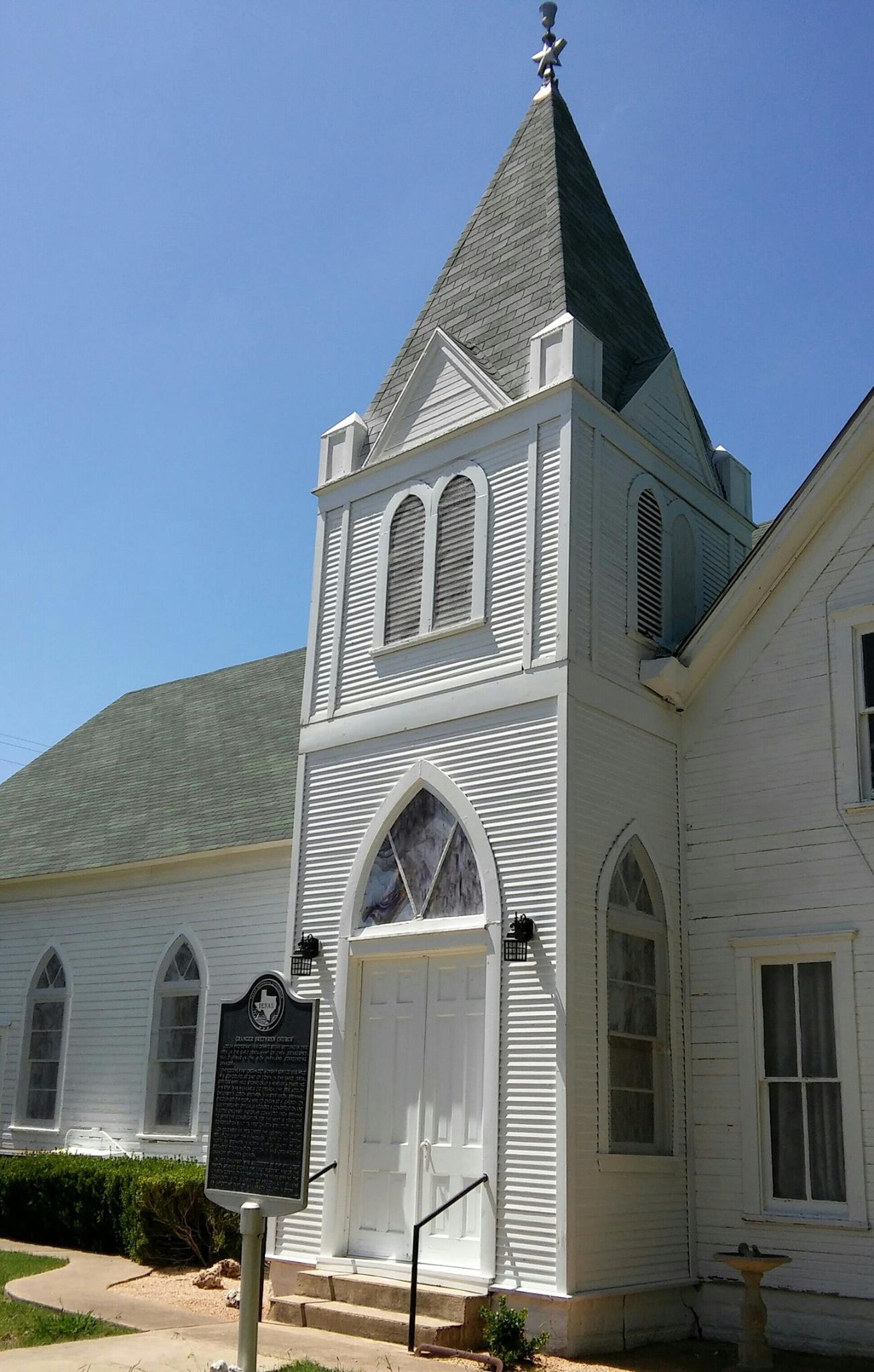 Close-up of the steeple and the Texas Historical Marker mounted on the front of the church.