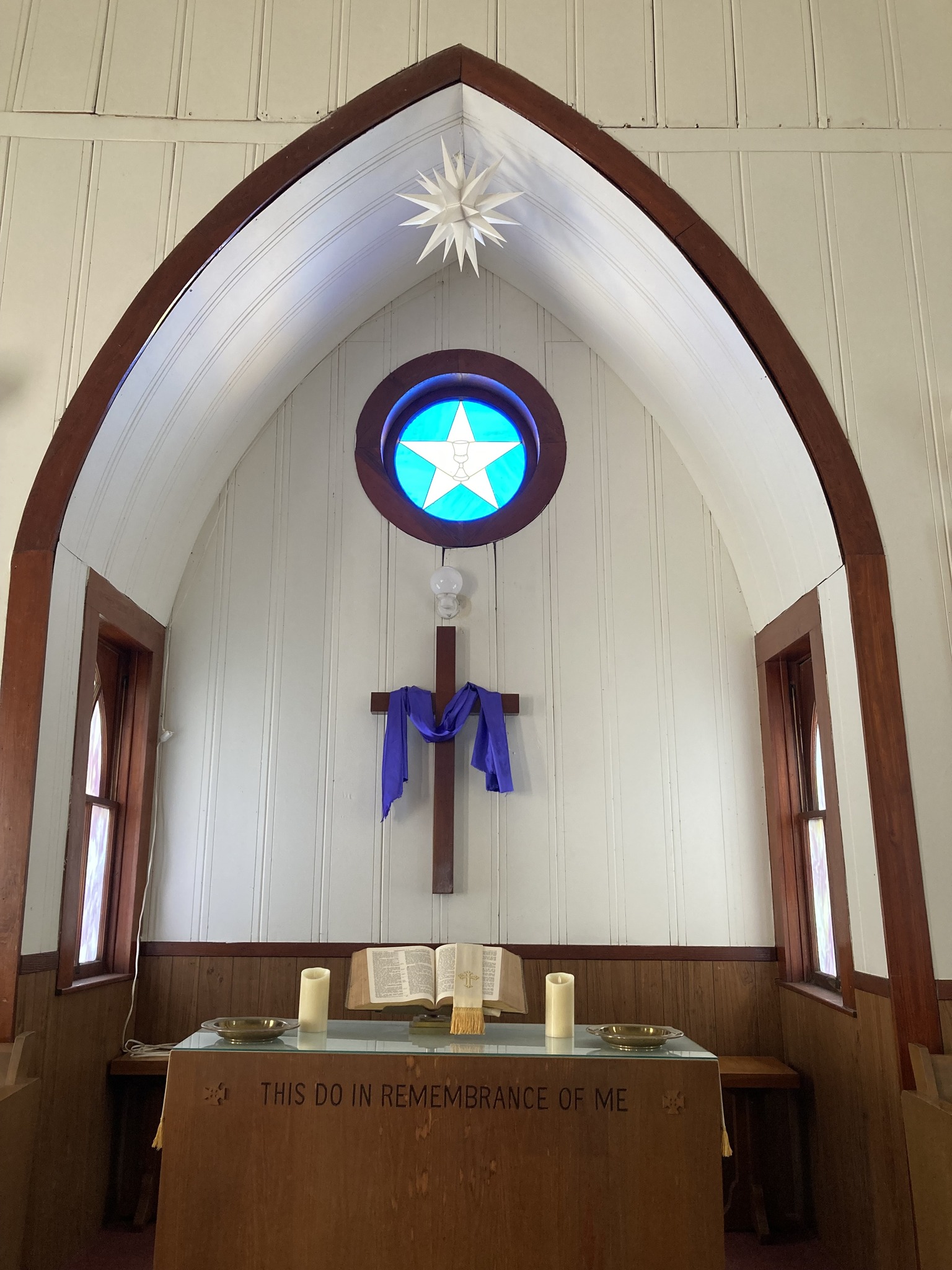 The chancel: Texas star window, Moravian star, cross with Lenten stole, communion table.